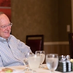 Franklin Park at Sonterra resident smiling at dinner in the dining room
