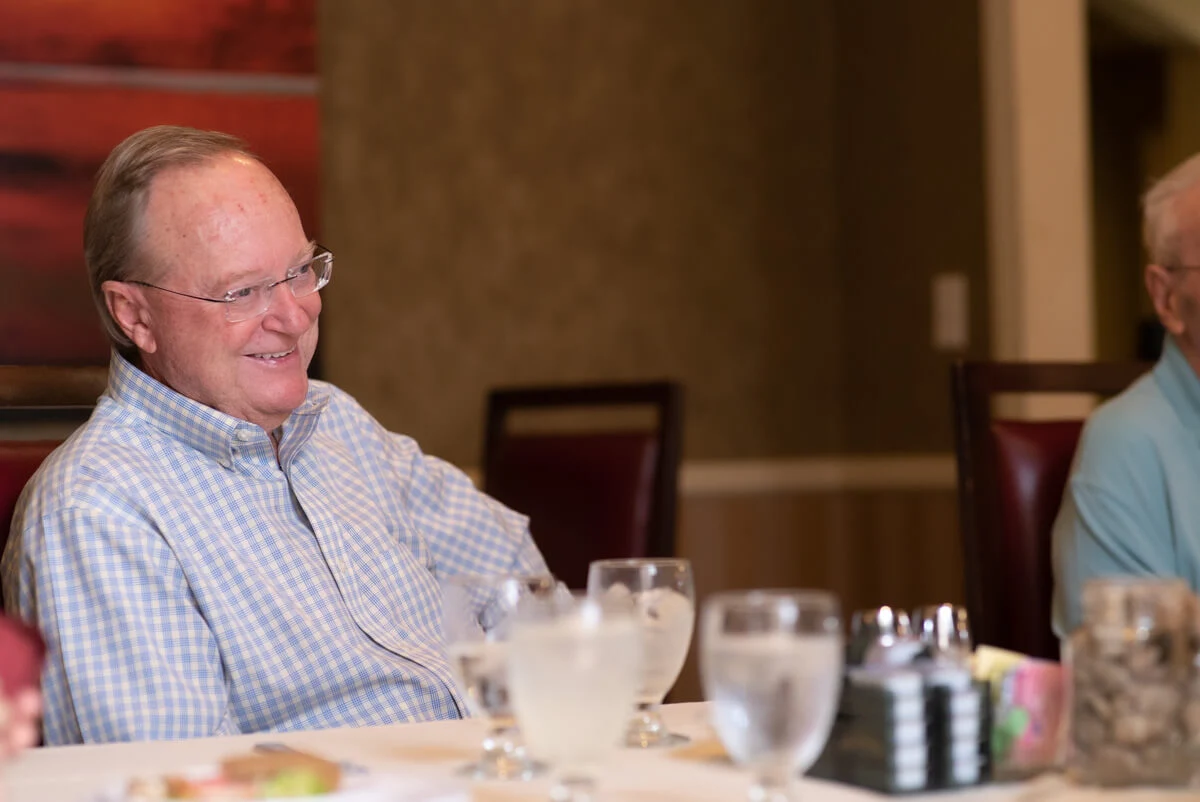 Franklin Park at Sonterra resident smiling at dinner in the dining room