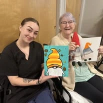 Avamere at Sandy senior living community offering assisted living, memory care, and respite care in Sandy, OR, resident and a staff member showing off their artwork