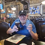 American House Westland Venoy senior living community offering independent living, assisted living, and respite care in Westland, MI, resident holding two beverages at an outing to a restaurant
