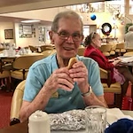 Meadowlark Estates Gracious Retirement Living Hawthorn Senior Independent Living in Lawrence, Kansas resident eating a hot dog in the dining room