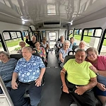 Seniors smiling aboard a community van from Charter Senior Living of Hopkinsville in Hopkinsville, KY, heading out for a group outing, promoting social engagement in assisted living and memory care.