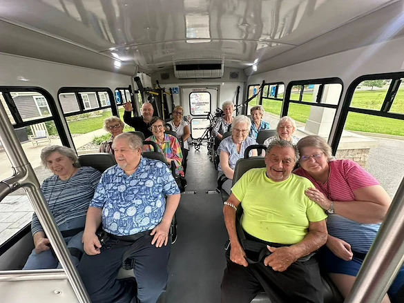 Seniors smiling aboard a community van from Charter Senior Living of Hopkinsville in Hopkinsville, KY, heading out for a group outing, promoting social engagement in assisted living and memory care.