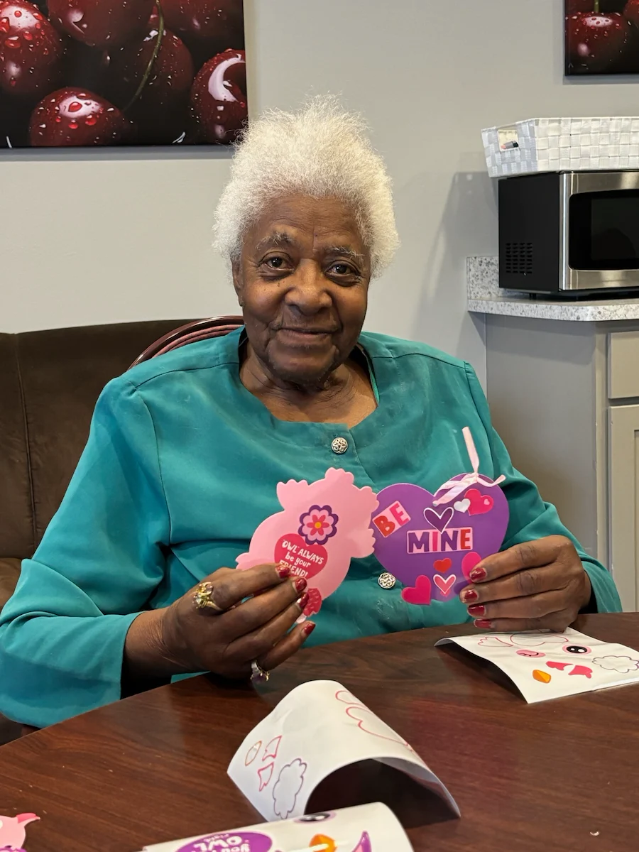American House Elmwood, senior living community offering independent living, assisted living, memory care, and respite care in Rochester Hills, MI, smiling resident doing Valentine's Day arts and crafts