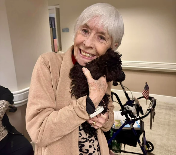 The Forum at The Crossing resident enjoys a visit from a dog