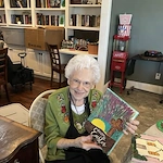 One of Orchard Ridge's residents showing off her art therapy painting she crafted