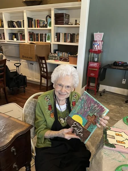One of Orchard Ridge's residents showing off her art therapy painting she crafted