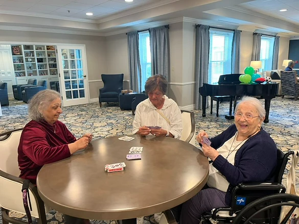Charter Senior Living of Dedham in Dedham, MA, residents socializing and playing cards to keep their minds strong