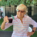 Covenant Living at the Samarkand in Santa Barbara, CA, smiling resident with a fun drink
