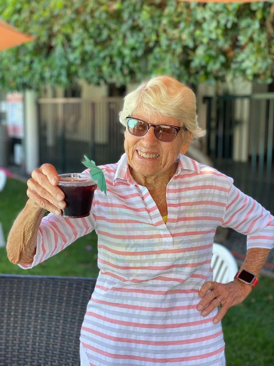 Covenant Living at the Samarkand in Santa Barbara, CA, smiling resident with a fun drink