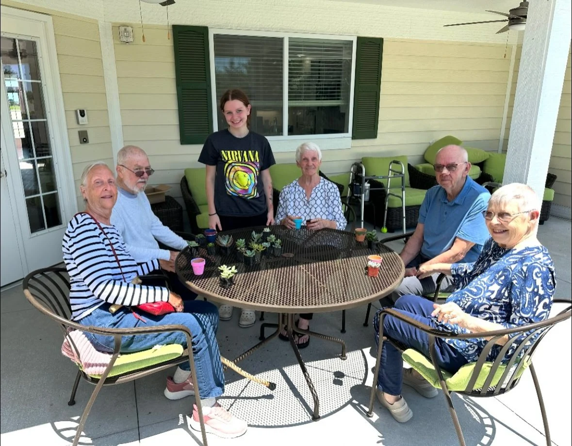 Faith Cottages Memory Care Basehor, KS, residents enjoy time outdoors and an engaging activity
