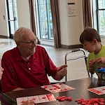 CopperWood at Prairie Trail senior living community offering assisted living and memory care in Ankeny, IA, resident enjoys visitors and a fun activity