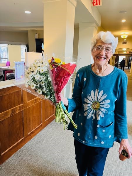 A resident of the Waters of Highland Park enjoying flowers donated by Trader Joes
