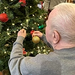 Credo Senior Living - Wichita, KS, resident helping decorate a Christmas tree