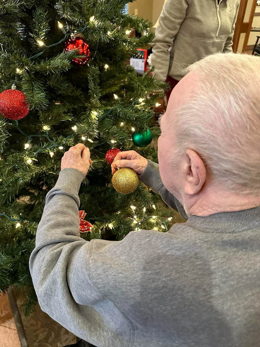 Credo Senior Living - Wichita, KS, resident helping decorate a Christmas tree