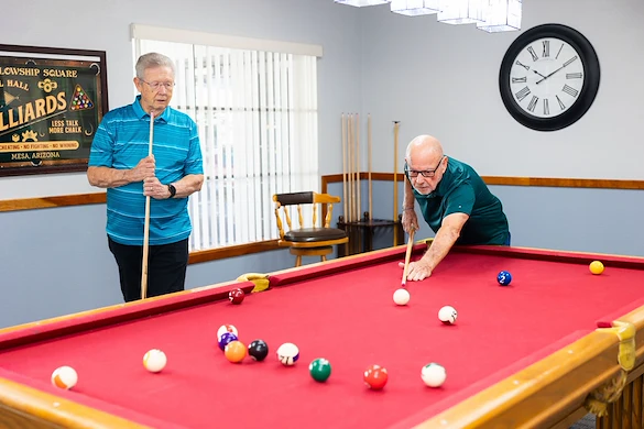 Residents playing pool at Fellowship Square Mesa