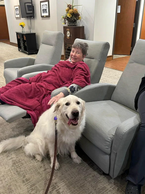 Credo Senior Living - Wichita, KS, resident enjoys a visit from a dog