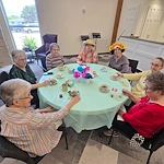 Kidron Bethel Village senior living community and continuing care retirement community (CCRC) offering independent living, assisted living, and respite care in North Newton, KS, ladies celebrating at a community Mother's Day event