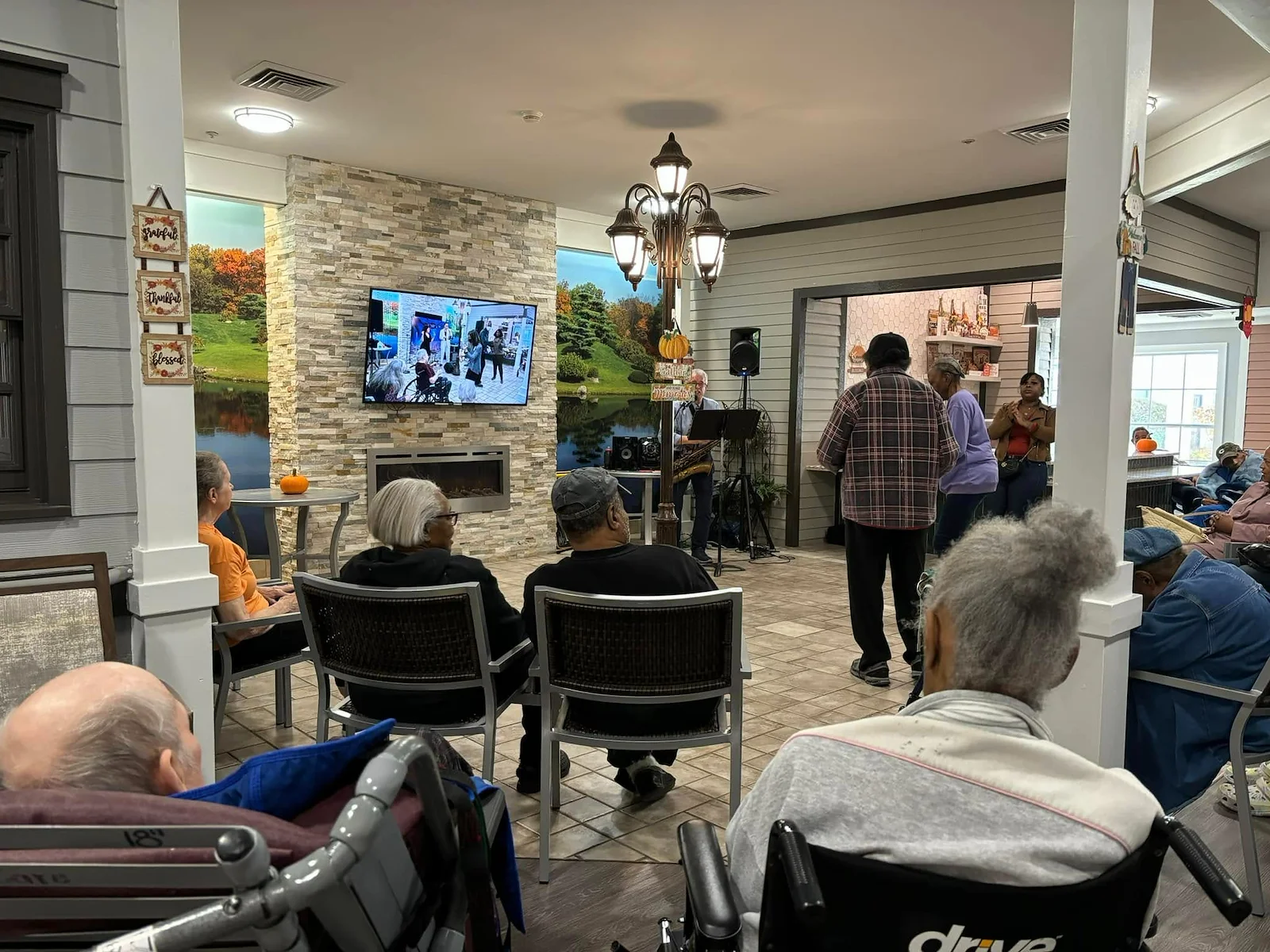 Seniors in assisted living and memory care at Charter Senior Living of Hazel Crest in Hazel Crest, IL, gathered to enjoy live music performed by a musician, with some residents dancing and others listening in a lively community event.